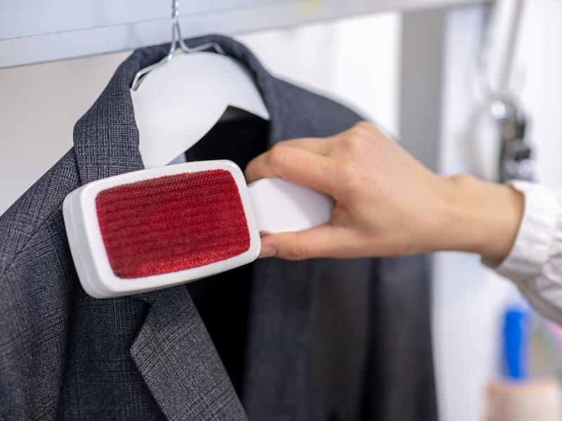 Brushing dust and lint from a tailored suit jacket