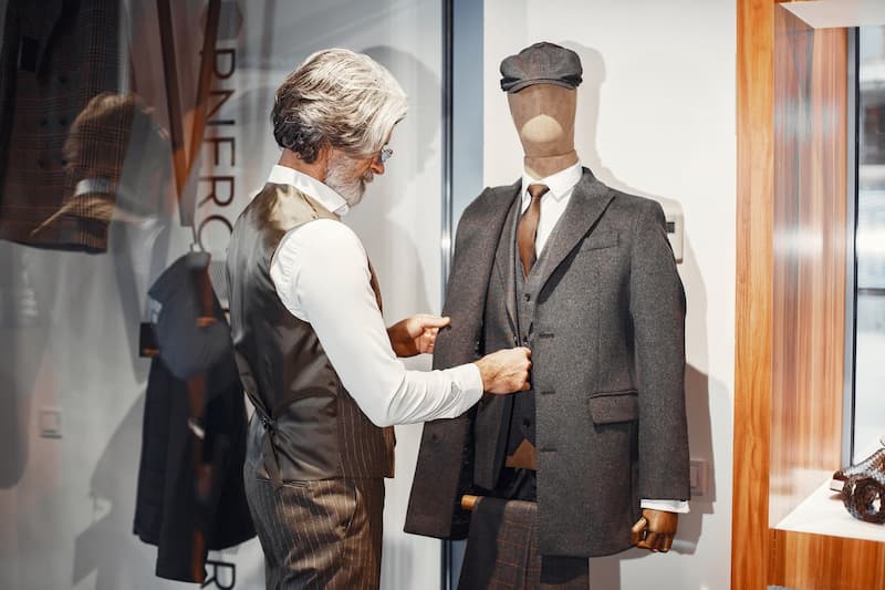 Tailor adjusting a mannequin in a shop