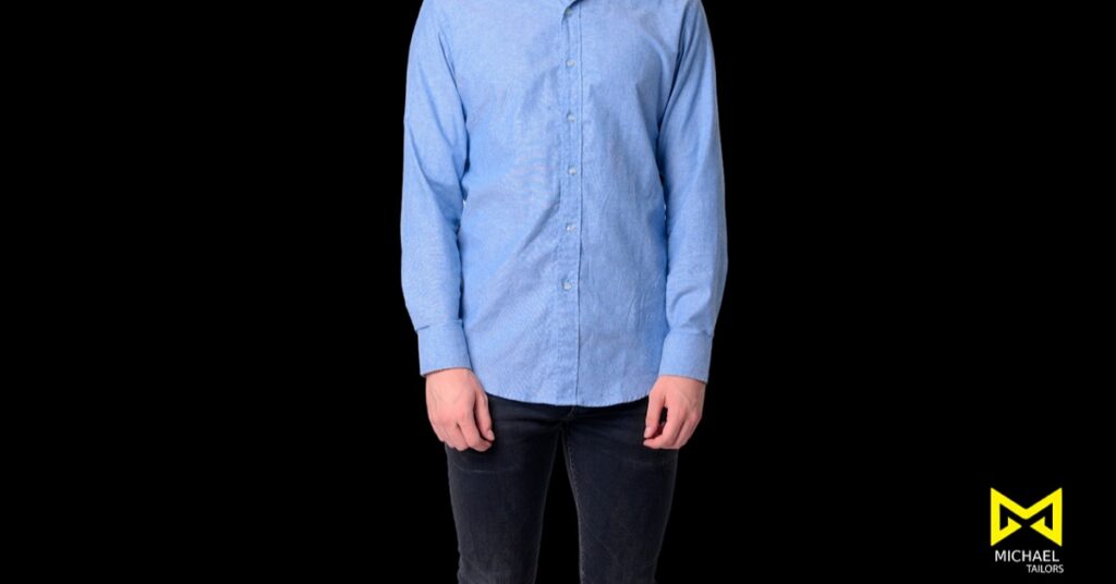 Man in blue shirt against black background