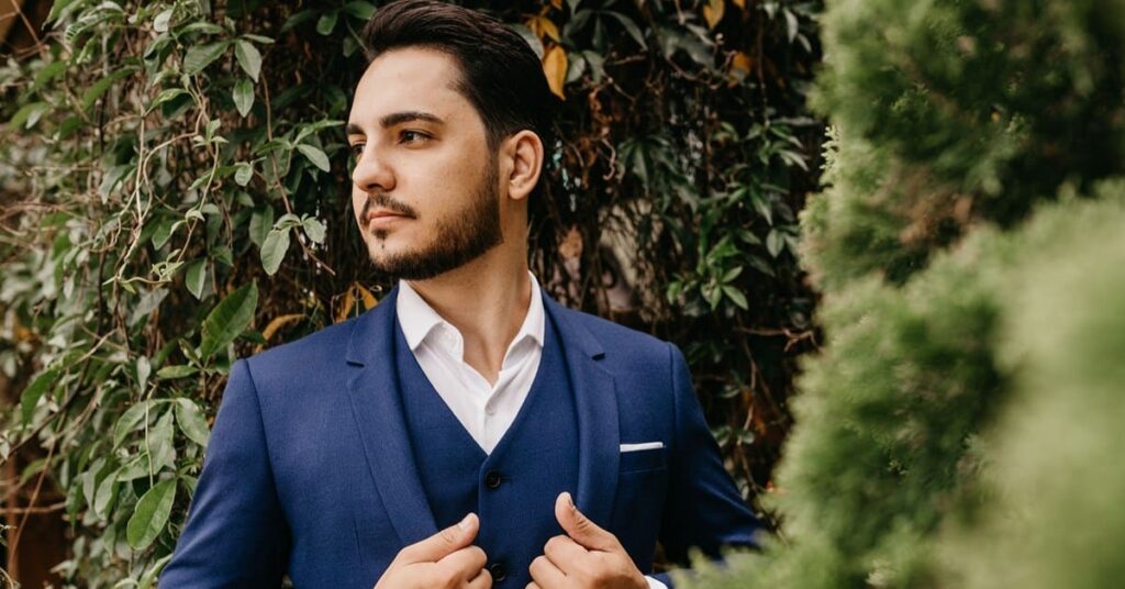 Man in blue suit against greenery
