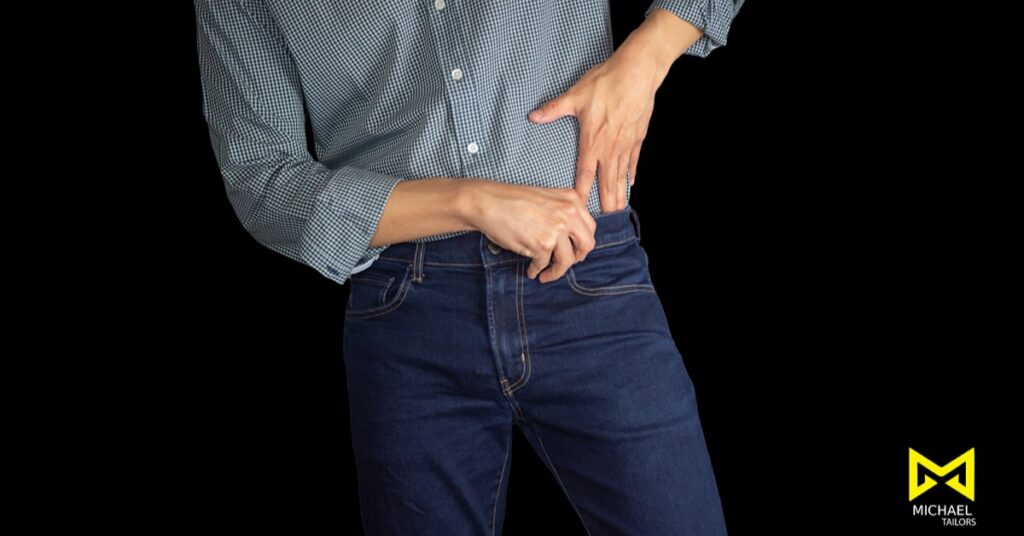 Person adjusting jeans with a checkered shirt