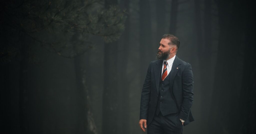 Man in suit standing in a foggy forest