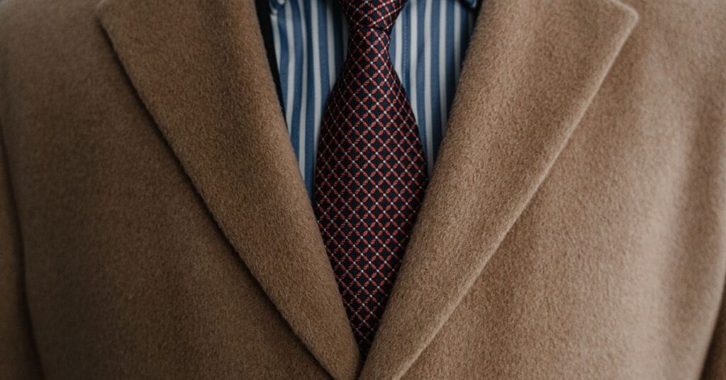 Close-up of a camel suit jacket with a patterned tie.