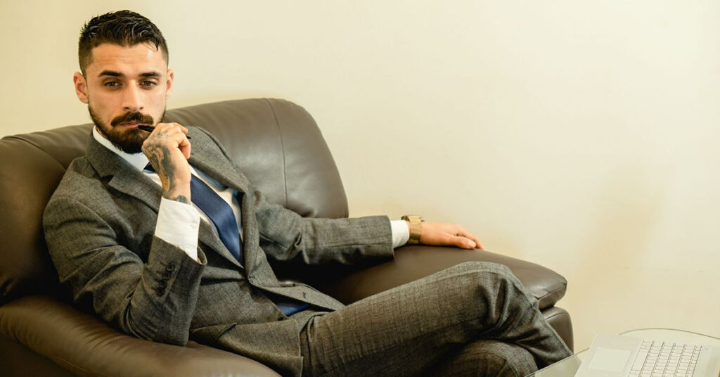 Man wearing a charcoal grey suit with a blue tie