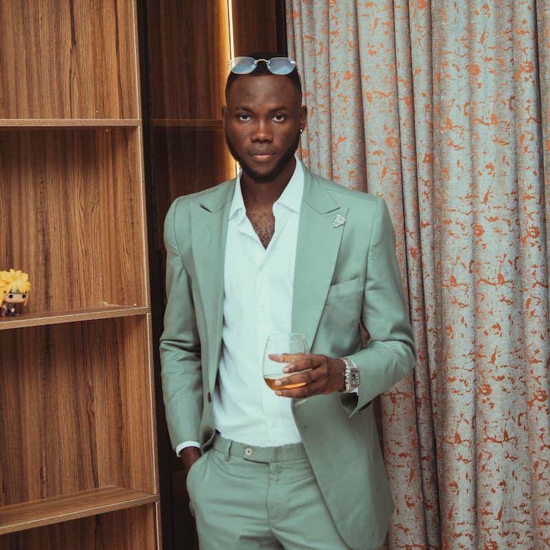 Man in green suit holding a drink