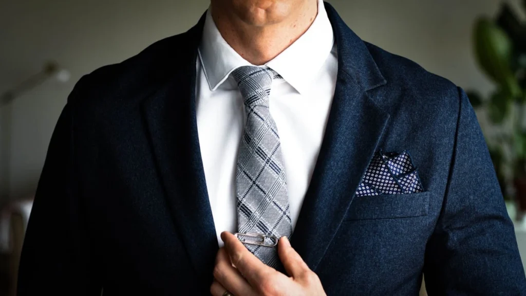 Man in a suit adjusting his tie