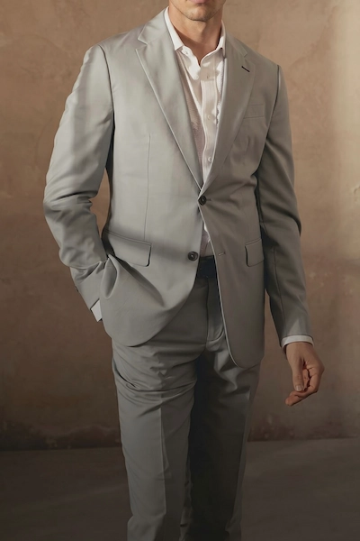 Man in gray suit against a neutral background
