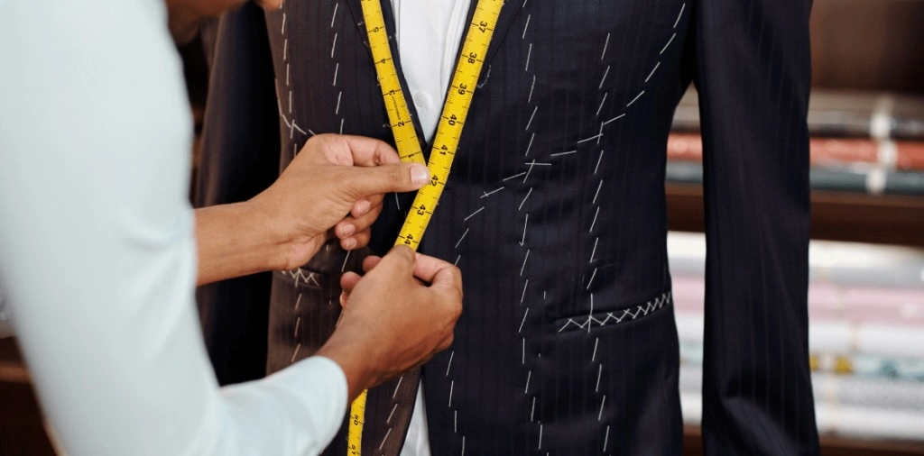 Tailor measuring a suit for fitting