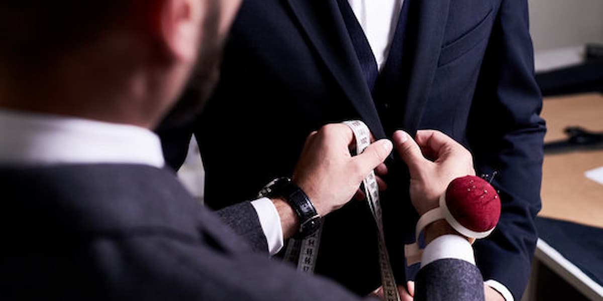 Tailor measuring a client for a suit