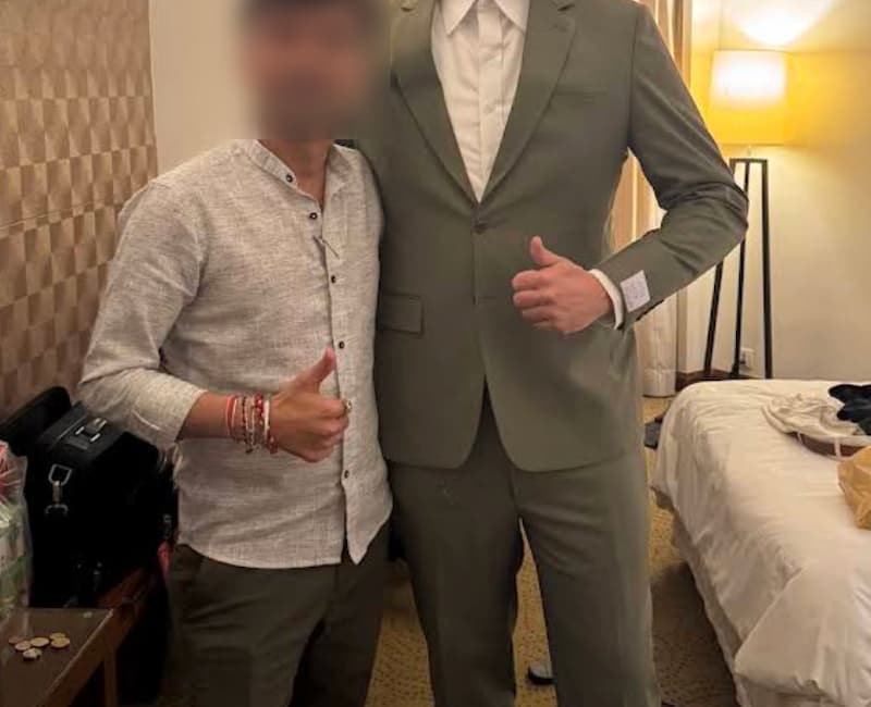 Two men posing in a hotel room